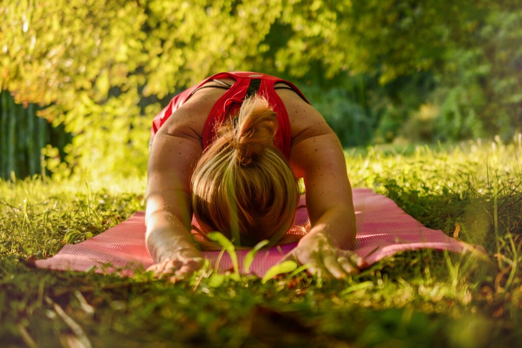 Žena cvičící jógu v přírodě.