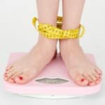 žena stojící na váze kvůli výpočtu BMI indexu.