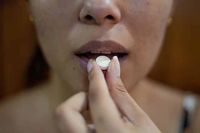 Žena užívající tabletku betablokátoru.